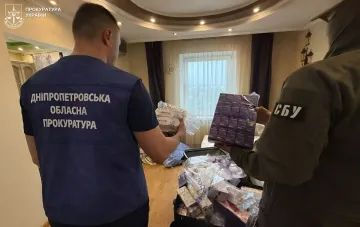 Працівники прокуратури та СБУ оглядають вилучені упаковки підробленого препарату для схуднення Biopatid під час обшуку