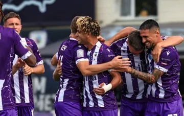 Fußballspieler des FC Lwiw in lila-weißen Trikots feiern ein Tor im ukrainischen Ligaspiel gegen Obolon