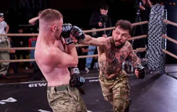 Бойці в кулачному поєдинку на турнірі M13 FIGHTS у Києві: один із спортсменів наносить прямий удар у рингу на баржі Perla Nera