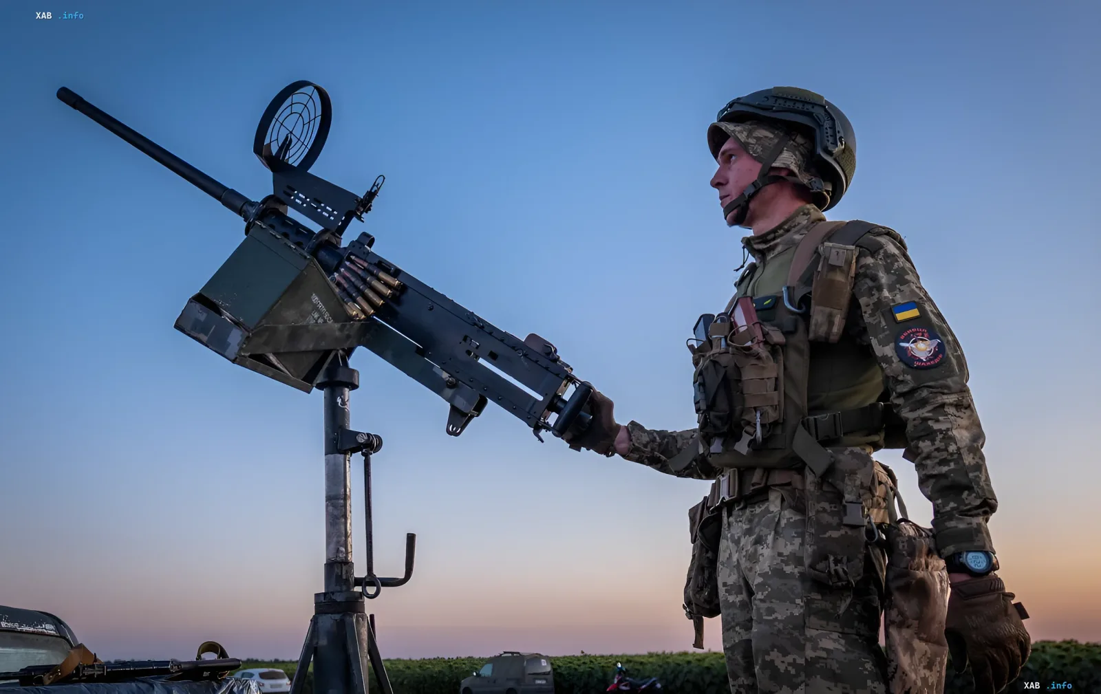 Ukrainian soldier at an anti-aircraft machine gun at dusk: air defense repels massive strike of over 410 Russian combat drones