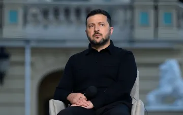 Mychajlo Selenskyj mit Mikrofon vor einem säulengeschmückten Gebäude, der Abfangraketen für die ukrainische Luftabwehr fordert
