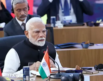 Indischer Vertreter am Tisch mit der Nationalflagge auf dem BRICS-Gipfel in Neu-Delhi bei der Verabschiedung der Erklärung 2026