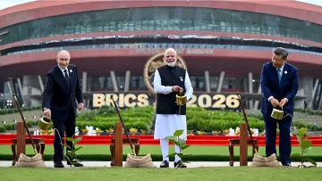 BRICS-Führer bei einer Baum-Pflanzzeremonie auf dem Gipfel in Neu-Delhi vor dem Gebäude mit BRICS-Logo