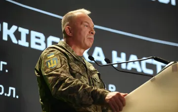 Презентація есею про Харківську наступальну операцію 2022 року в Києві: військовий у камуфляжі з нашивкою ЗСУ біля трибуни з мікрофонами