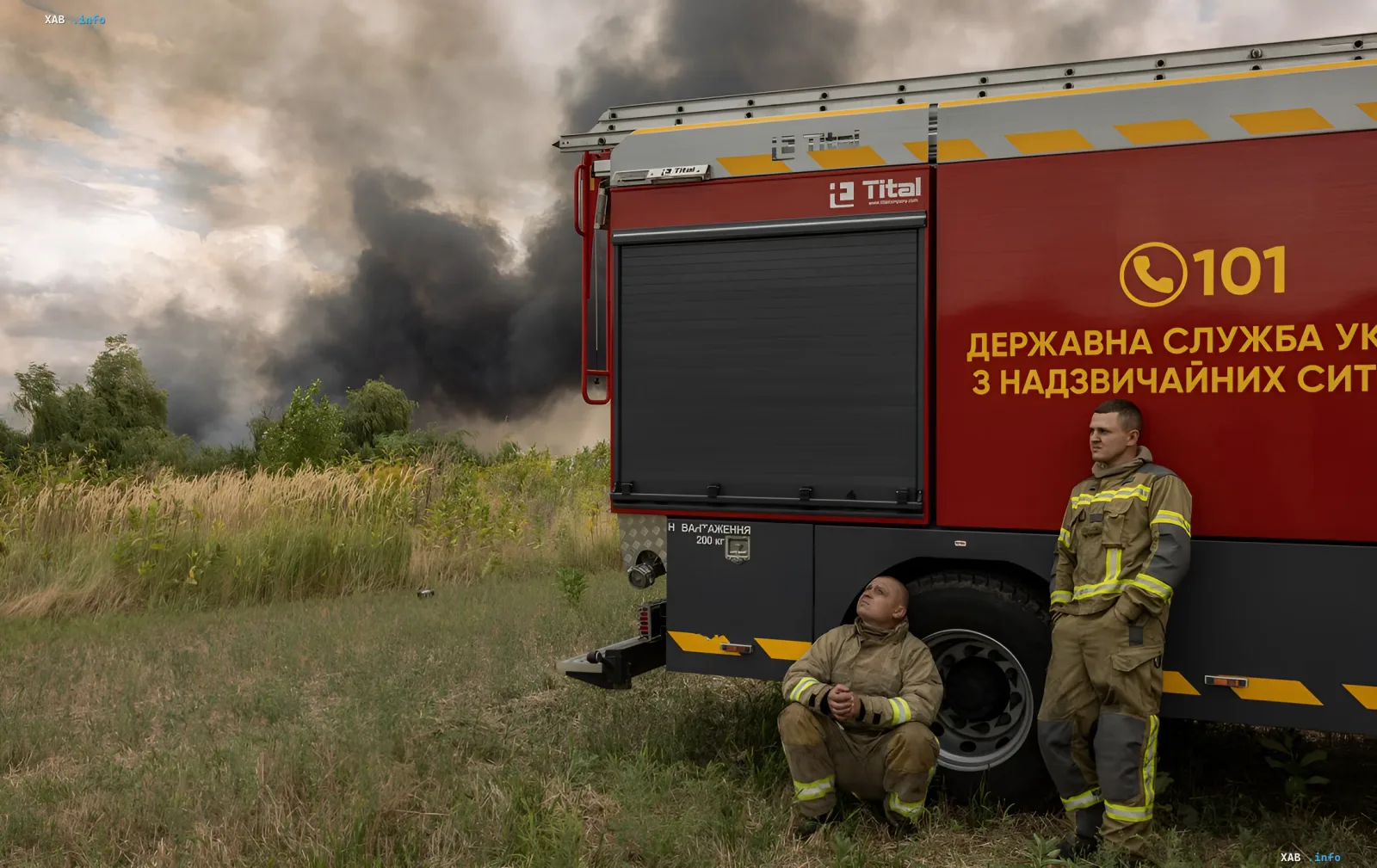Пожарные отдыхают у пожарной машины на фоне дыма от горящего поля на Житомирщине