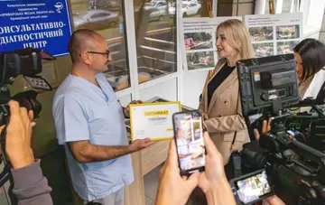 Presentation of a 5 million hryvnia certificate at the reopened consultative and diagnostic center of Kriiv Rih Hospital No. 3, surrounded by press cameras