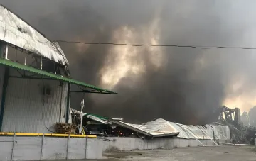 EVA sorting center in Odesia destroyed by a Russian missile strike: thick black smoke rising over the burned warehouse building