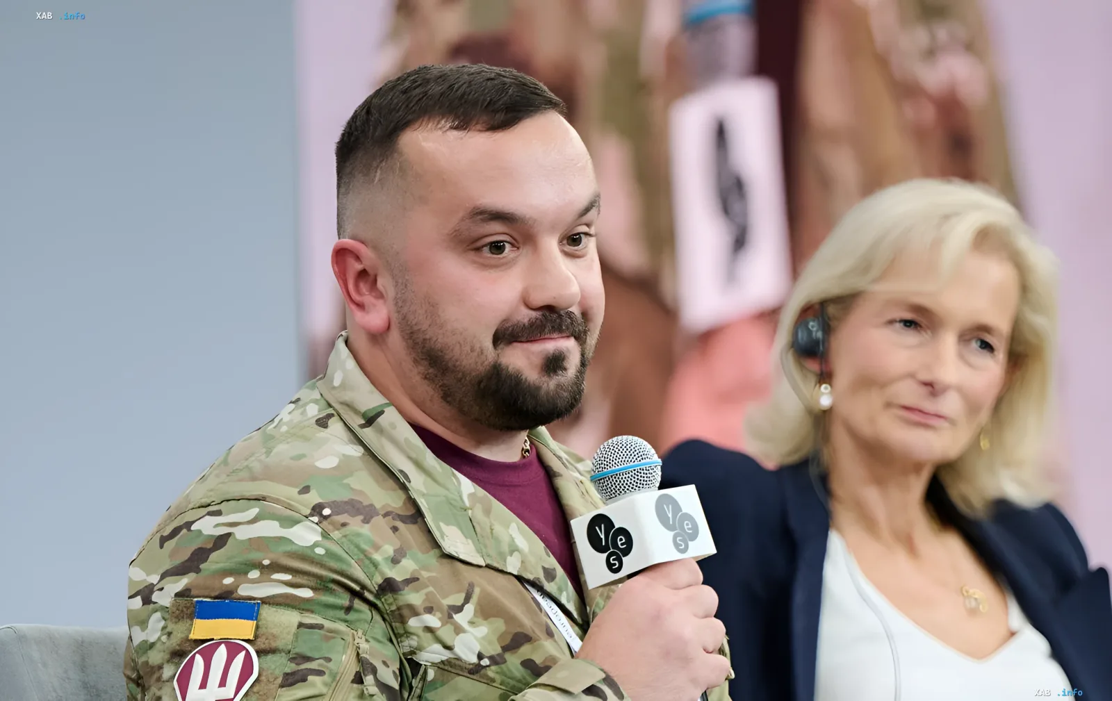 Начальник ПВО 7-го корпуса ДШВ в камуфляже с украинским флагом на рукаве выступает с микрофоном на панельной дискуссии