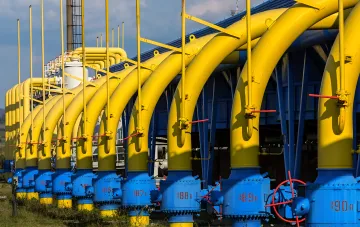 Газотранспортна інфраструктура України: ряд жовтих газопроводів із вузлами обліку на тлі компресорної станції
