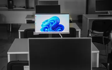 Рабочая станция с включённым монитором Windows 11 в компьютерном классе, демонстрирующая встроенную защиту системы