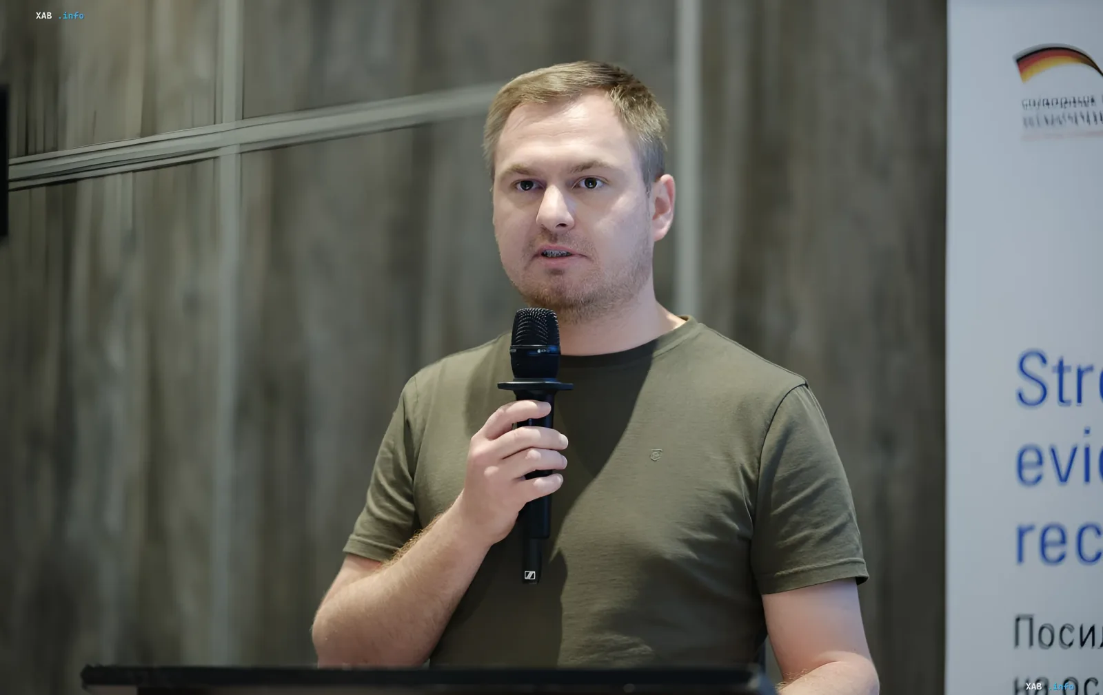 Man speaking into a microphone at a public event in the context of Prosecutor General Kravchenko's dismissal and the 'Carthage' case