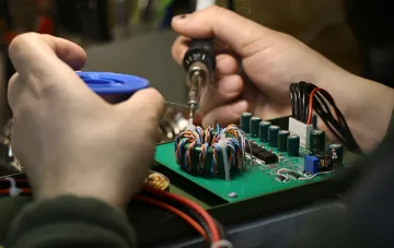 Löten einer Elektronikplatine in einer ukrainischen Rüstungselektronik-Fertigung: Produktionsprozesse, die der russische Geheimdienst über Insider ausspioniert