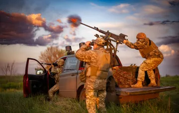 Українські військові ведуть вогонь із зенітного кулемета по дронів під час нічної атаки БПЛА