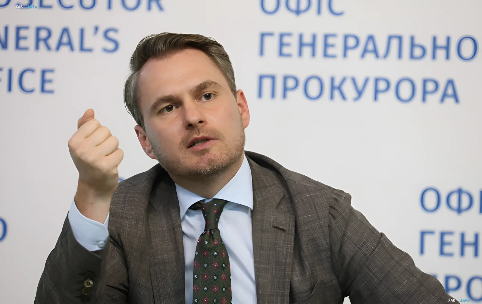Представитель Офиса генерального прокурора на фоне стенда ОГП во время комментария по делу о подозрении директору НАБУ