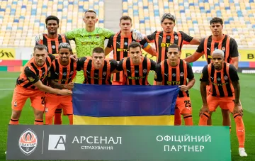 Футболісти «Шахтаря» в оранжево-чорній формі тримають український прапор перед матчем УПЛ з «Чорноморцем», який вивів команду Арди Турана на лідируючі позиції
