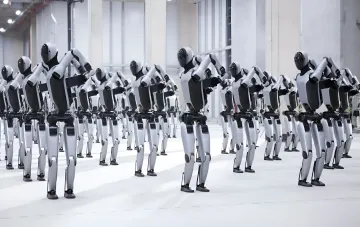 Reihen von Humanoid-Robotern auf einer Massenproduktions-Förderlinie in China bei synchroner Bewegung