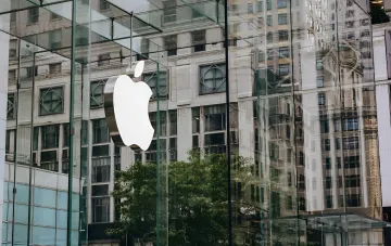 Логотип Apple на скляному фасаді магазину на тлі новин про чіп M5 Ultra в базі Geekbench 7