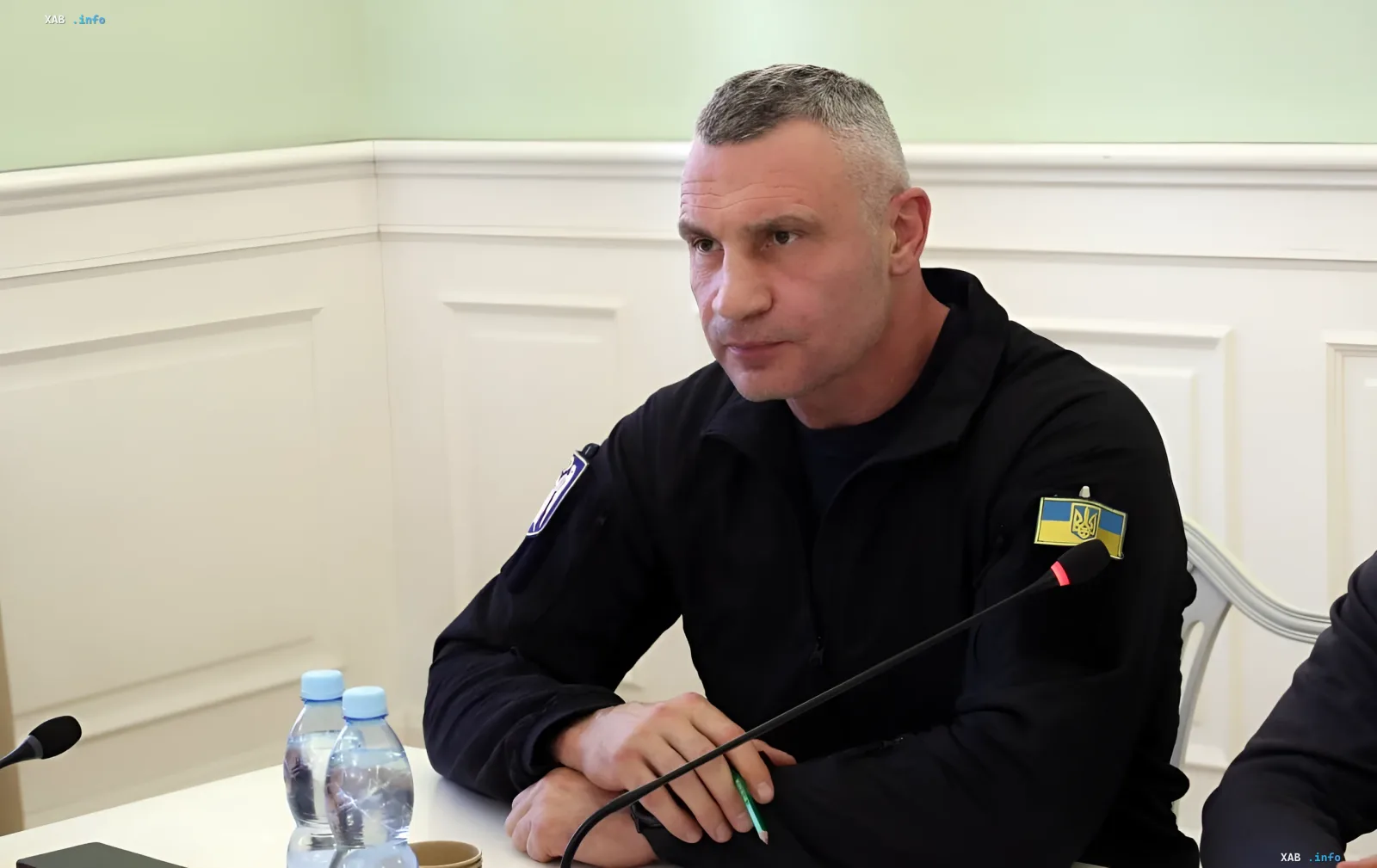 Sitzung zur Ausarbeitung von Vergünstigungen für Unternehmen, die von russischen Angriffen betroffen sind: Teilnehmer mit ukrainischer Flaggenabzeichen am Tisch mit Mikrofonen