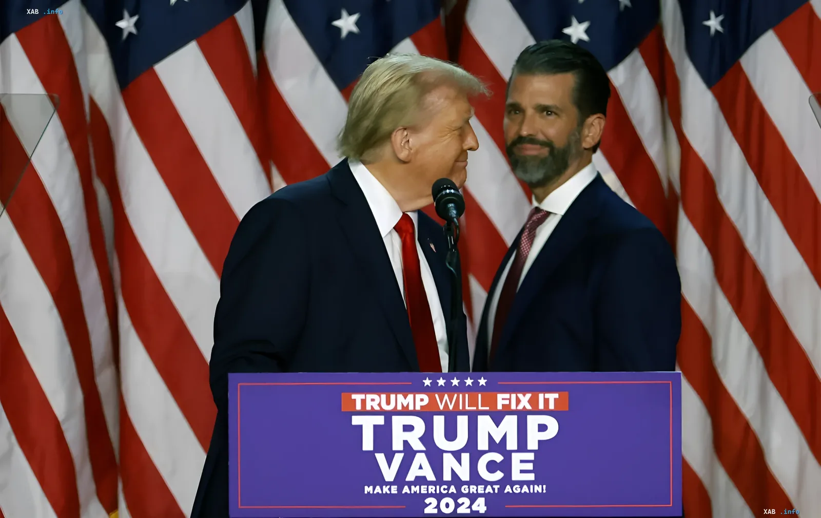 Donald Trump and JD Vance at the Trump-Vance 2024 campaign podium against a backdrop of US flags amid the Congressional probe into a Russian oligarch's alleged bribe at Trump Jr.'s wedding