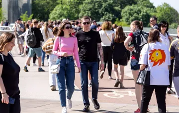 People walking in light summer clothes on a sunny street on a warm September day in Ukraine