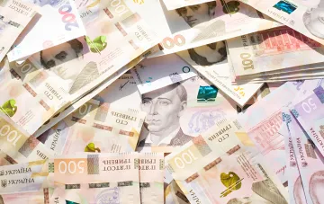 Ukrainian hryvnia banknotes of various denominations illustrating the 2027 state budget: defense spending and public sector salaries