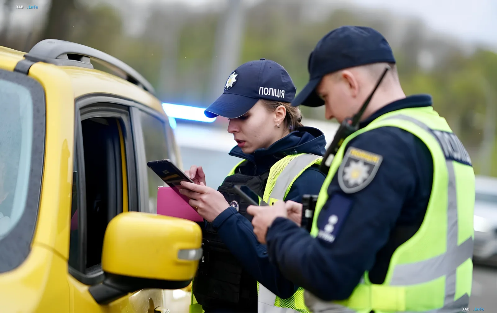 Police officers recording a speeding violation on a tablet next to a patrol vehicle amid the failure of a bill to raise speed fines in Ukraine's parliament