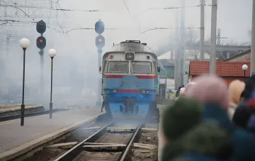 Пасажирський електропоїзд на тлі диму після атаки дрона на напрямку Київ–Миколаїв, евакуація пасажирів