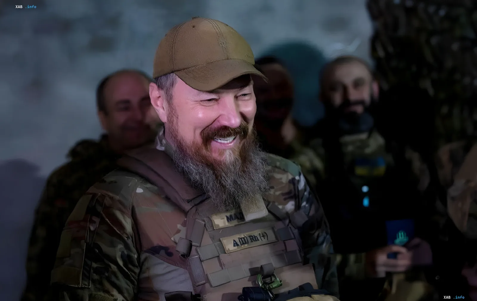 «Мадяр» у камуфляжі та тактичному жилеті з нашивкою «МАД» на тлі бійців 427-ї бригади СБС «Рарог»