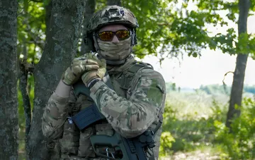 Soldat in Tarnkleidung mit Gewehr im Wald – Illustration zum Thema unbefugtes Verlassen der Einheit und GBF-Fahndung in der Ukraine
