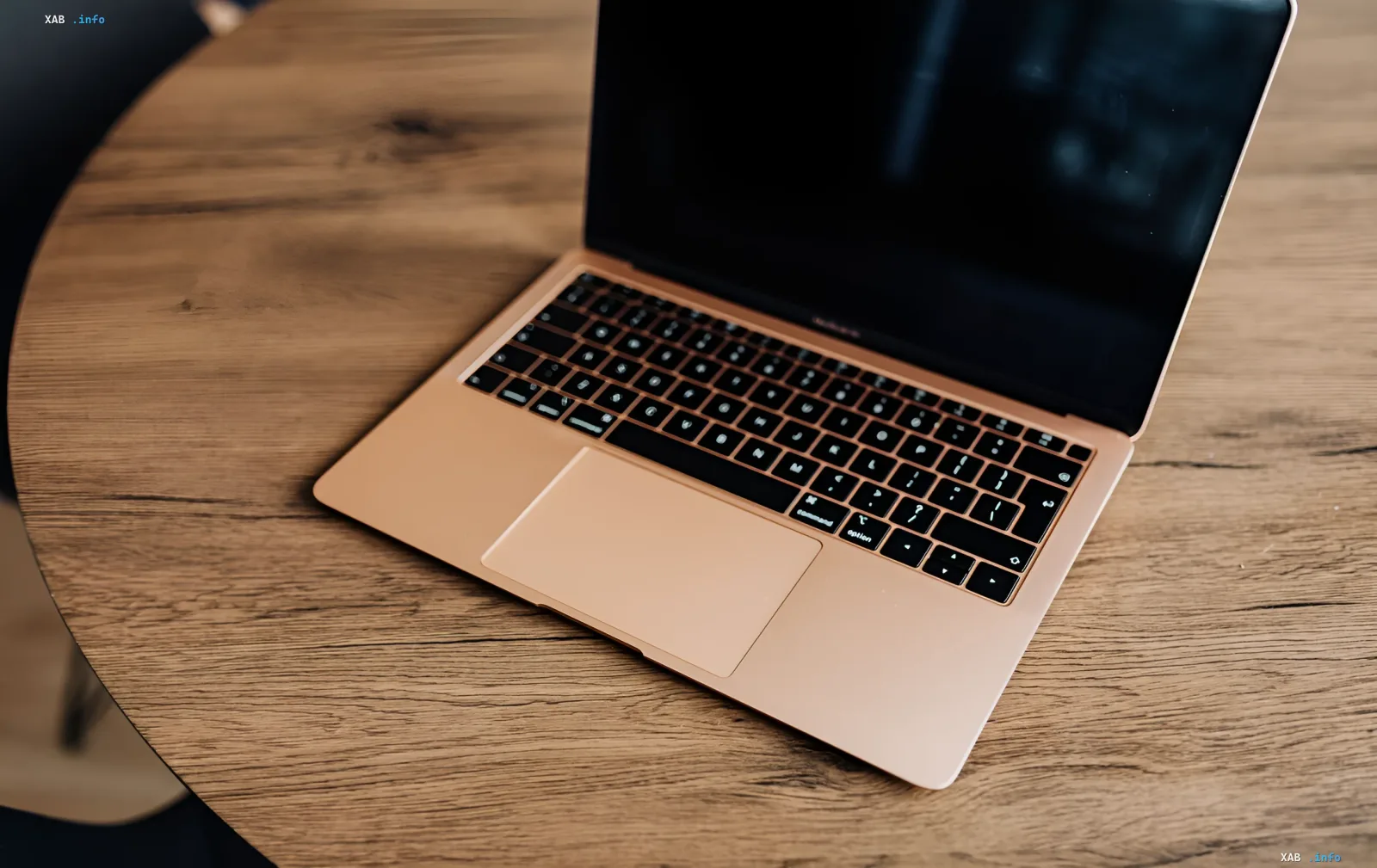 Золотистый MacBook на деревянном столе: трекпад и клавиатура в контексте новых жестов macOS 27 Golden Gate