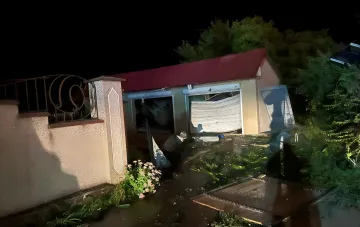Зруйнований приватний будинок в Одесі після нічного удару: пошкоджені ворота та уламки на тлі темного неба