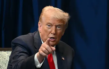 Дональд Трамп указывает пальцем во время выступления на фоне синего задника; Белый дом подтвердил подписание санкций против РФ с пошлинами до 100%