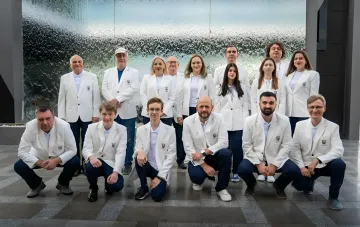 Ukrainisches Schachteam in weißen Jacken mit Dreizack-Logo bei der Schacholympiade in Samarkand