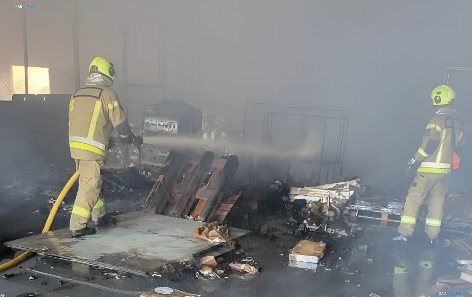 Firefighters extinguish the remains of the burned-down warehouse of Yelena Zelenska's Foundation with humanitarian aid in Kyiv