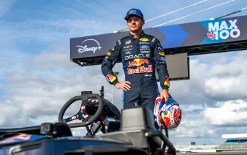 Max Verstappen in his Red Bull Racing suit on the car ahead of the MAX VS 100 show at Silverstone, where he overtook 100 karts