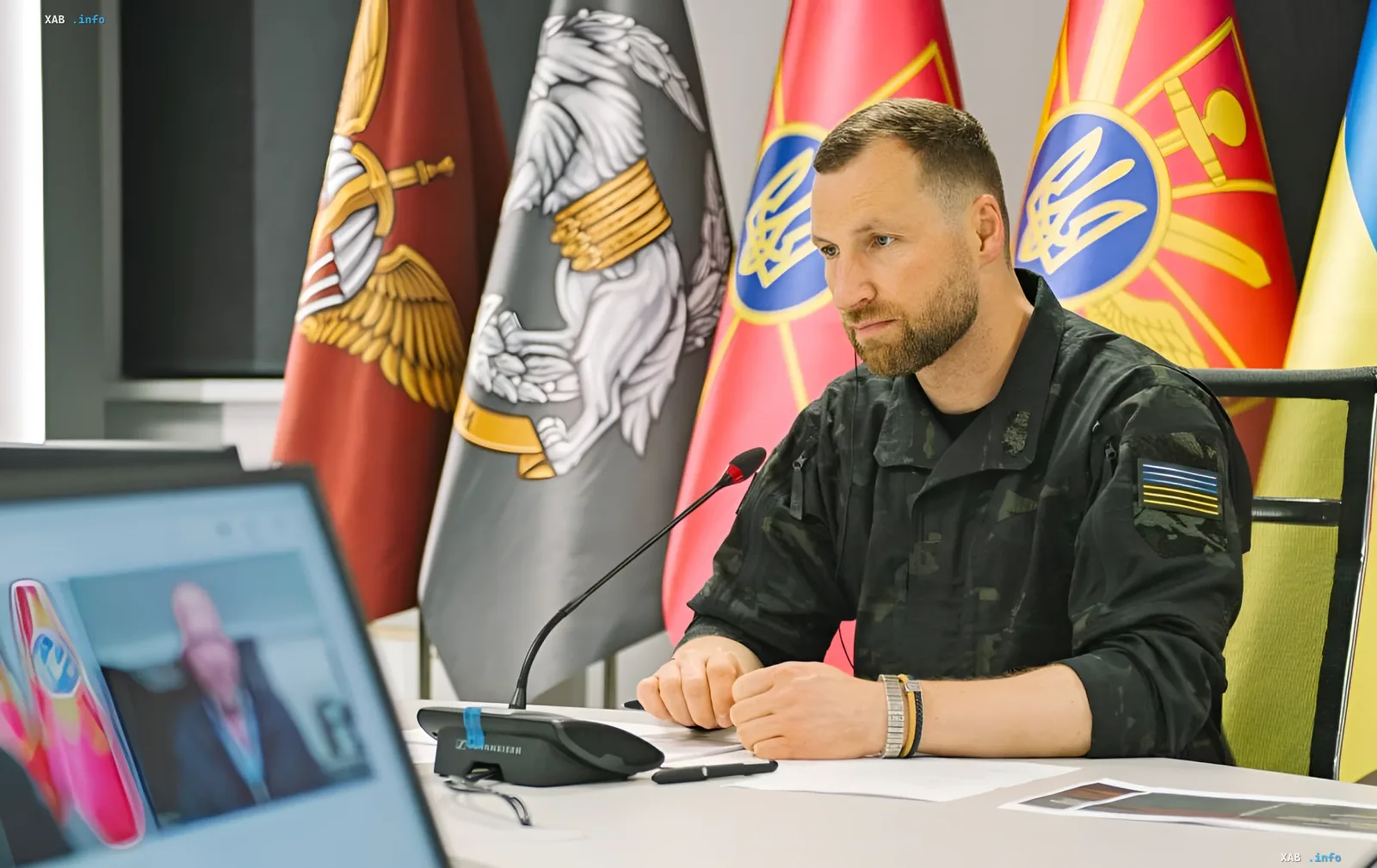 Oleksandr Khmara at a defense sector meeting in front of Ukrainian flags — discussing whether to continue Fedorov's reforms