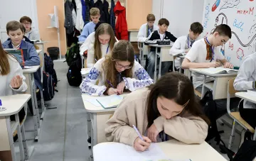 Ninth-grade students at their desks in a Ukrainian school during a lesson with textbooks and notebooks