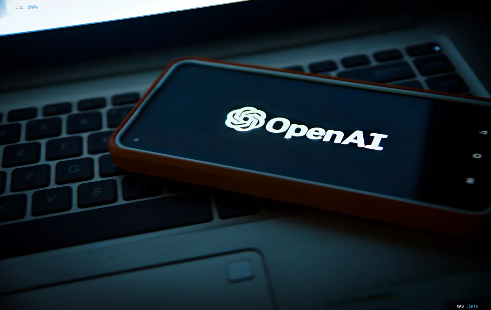 Smartphone mit OpenAI-Logo auf dem Display, der auf einer Laptop-Tastatur liegt: Unternehmen enthüllt Vorfälle von Umgehungen von KI-Anweisungen
