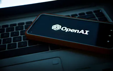 Smartphone mit OpenAI-Logo auf dem Display, der auf einer Laptop-Tastatur liegt: Unternehmen enthüllt Vorfälle von Umgehungen von KI-Anweisungen