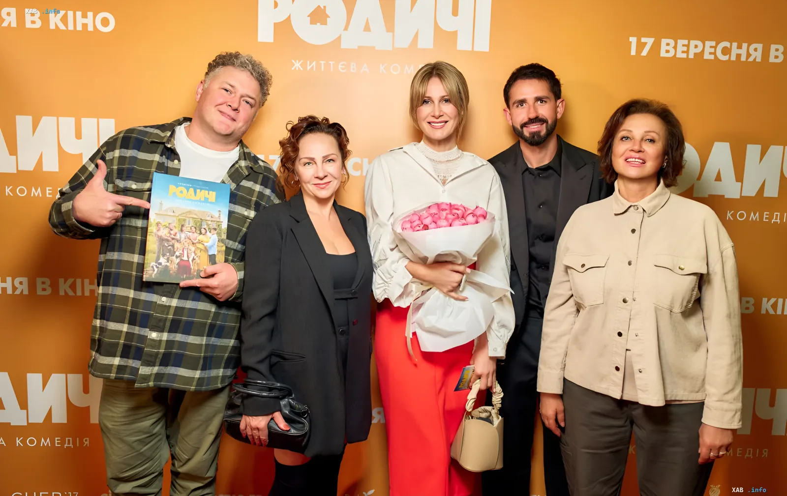 Команда украинской комедии «Родичі» Евгения Таллера на презентации фильма: режиссёр и актёры позируют на фоне баннера с постером и букетом роз