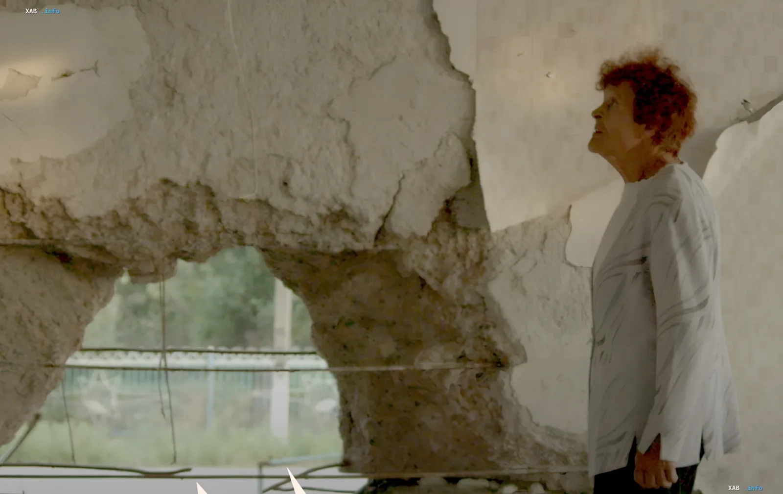 A woman by a damaged wall in a frame from the documentary 'Traces', submitted by Ukraine for the 2027 Oscars