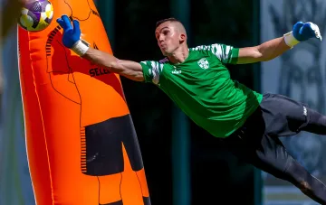 Obolon goalkeeper Fedorovsky in JAKO kit performing a dive during training with a mannequin