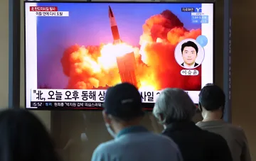 Südkoreanische Bewohner sehen einen Fernsehbildschirm mit einer Meldung über den Start einer nordkoreanischen ballistischen Rakete