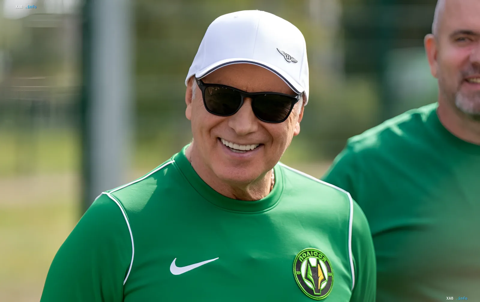President of Polissya in the club's green kit and white cap smiles on the stands during a UPL match, in the break of which a chess duel with the head of Veres took place