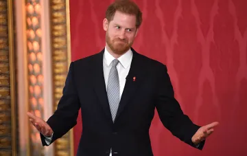 Prinz Harry in dunklem Anzug mit offenen Händen bei seinem ersten öffentlichen Auftritt nach der Rückkehr in Großbritannien