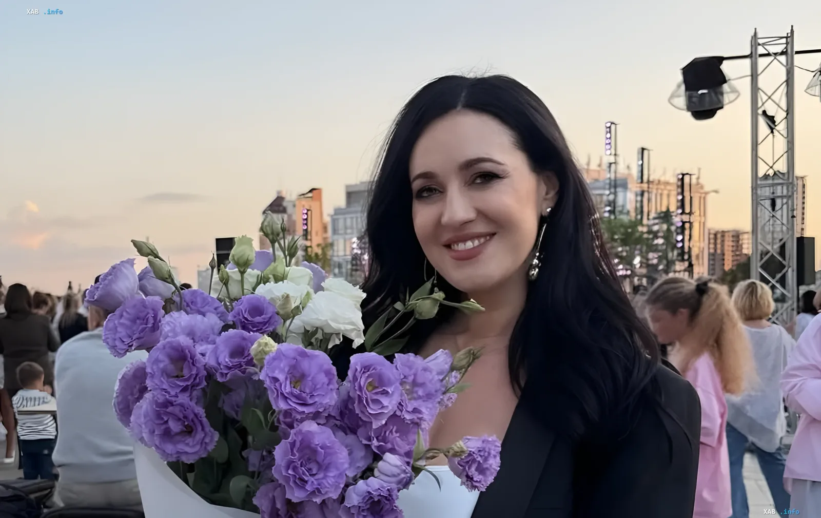Соломия Витвицкая на 41-й неделе беременности с букетом фиолетовых и белых эустом на городской площади на закате
