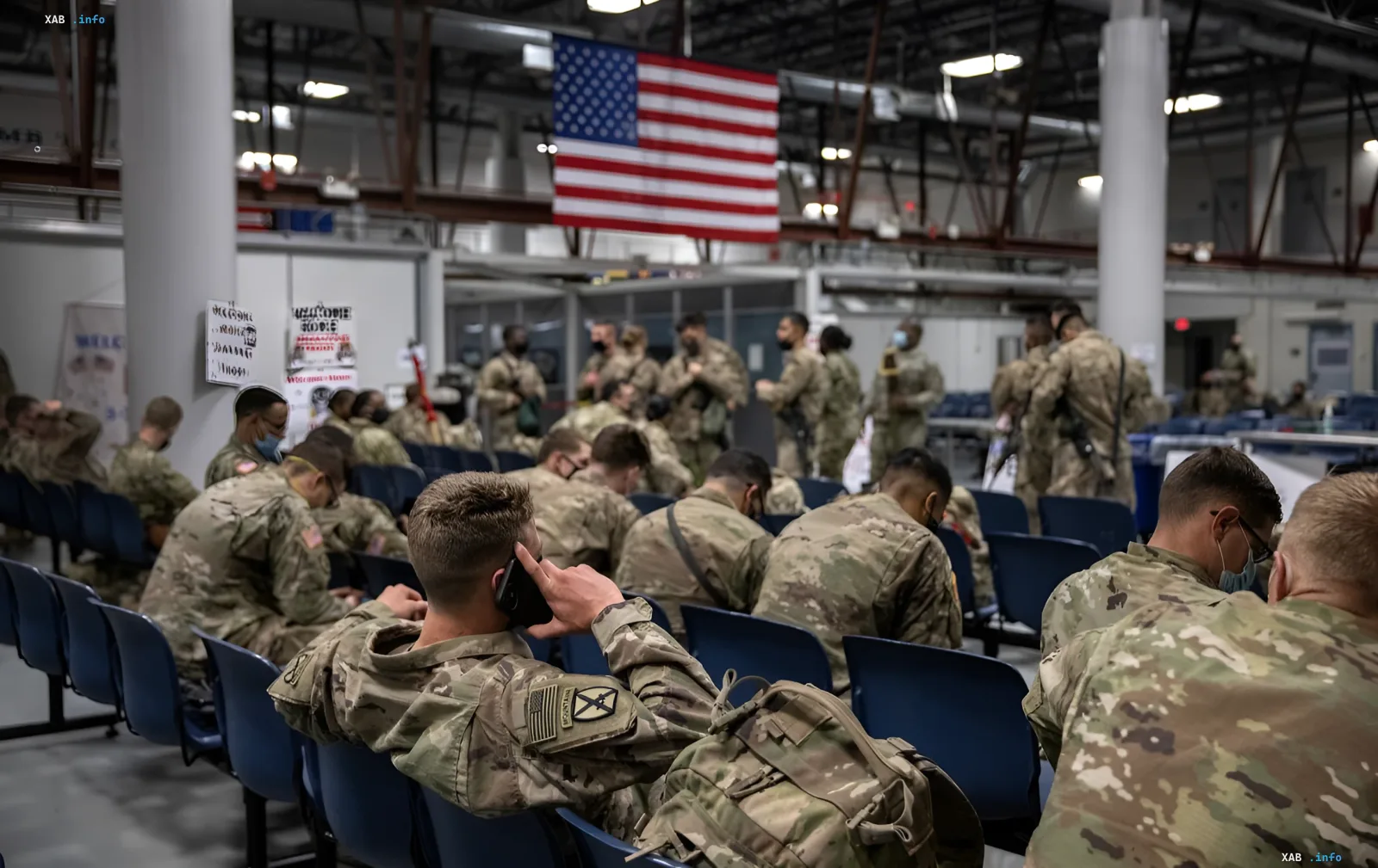 US soldiers in camouflage in a waiting hall with an American flag amid Pentagon talks of withdrawing troops from Europe