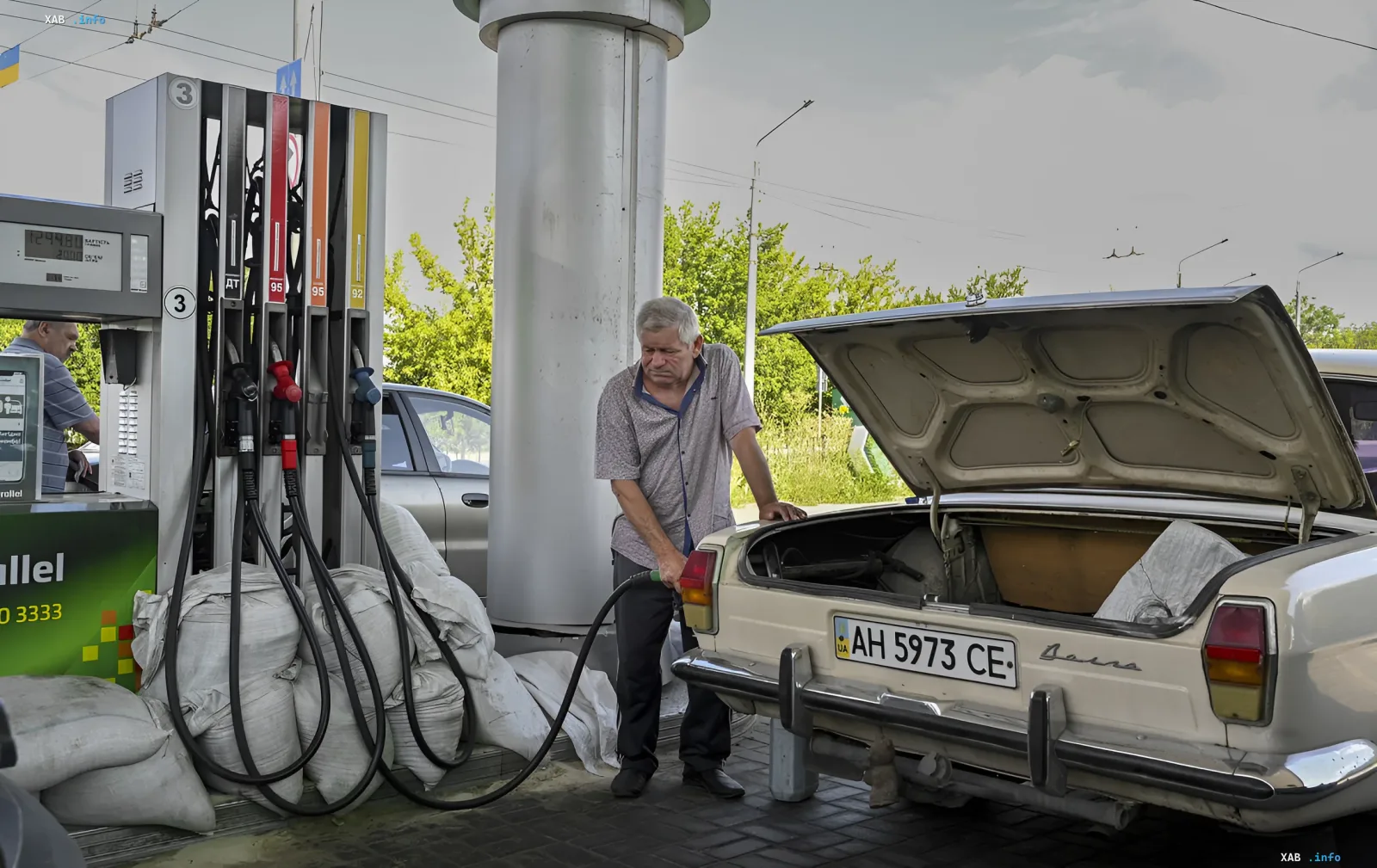 Водитель заправляет бензином старую «Волгу» на АЗС в Украине на фоне роста цен на топливо
