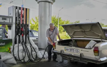 Водитель заправляет бензином старую «Волгу» на АЗС в Украине на фоне роста цен на топливо