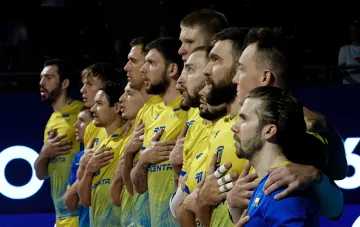 Игроки сборной Украины по волейболу в жёлто-синей форме слушают гимн перед матчем с Румынией на Евро-2026